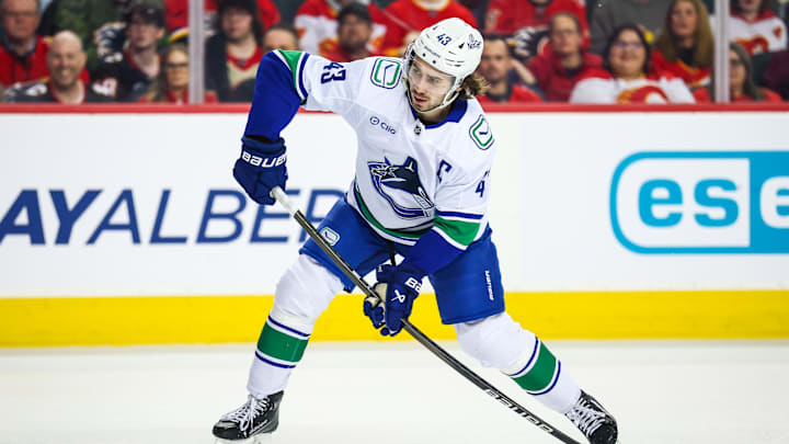 Mar 12, 2025; Calgary, Alberta, CAN; Vancouver Canucks defenseman Quinn Hughes (43) shoots the puck against the Calgary Flames during the first period at Scotiabank Saddledome. Mandatory Credit: Sergei Belski-Imagn Images