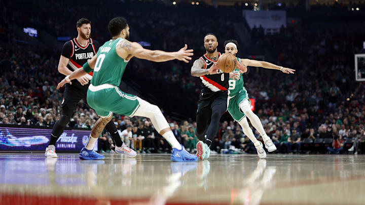 Mar 17, 2023; Portland, Oregon, USA; Portland Trail Blazers point guard Damian Lillard (0) passes the ball as Boston Celtics small forward Jayson Tatum (0) defends during the first half at Moda Center. Mandatory Credit: Soobum Im-Imagn Images