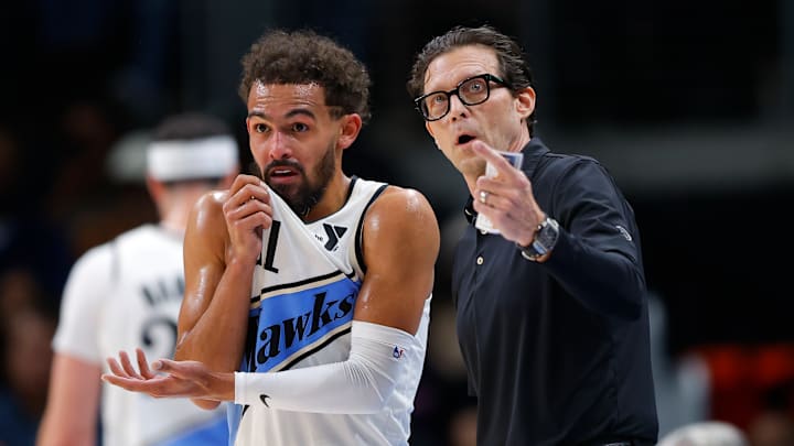 Trae Young #11 and head coach Quin Snyder of the Atlanta Hawks chat during a break in action against the Chicago Bulls.