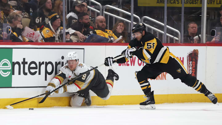 Mar 1, 2026; Pittsburgh, Pennsylvania, USA;  Vegas Golden Knights center Jack Eichel (9) reaches for a loose puck against Pittsburgh Penguins defenseman Kris Letang (58) during the third period at PPG Paints Arena. Mandatory Credit: Charles LeClaire-Imagn Images