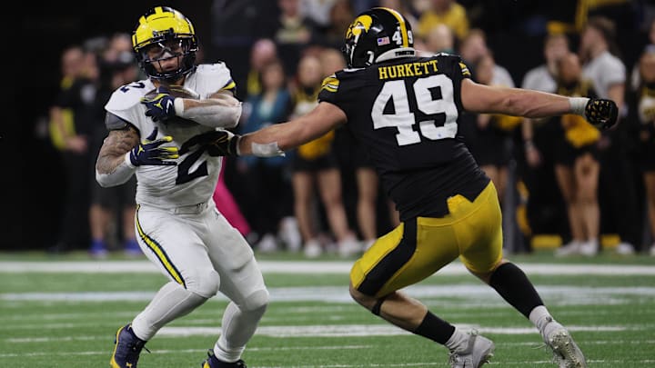 Dec 2, 2023; Indianapolis, IN, USA; Michigan Wolverines running back Blake Corum (2) runs against Iowa Hawkeyes defensive lineman Ethan Hurkett (49) during the second half of the Big Ten Championship game at Lucas Oil Stadium. Mandatory Credit: Trevor Ruszkowski-Imagn Images