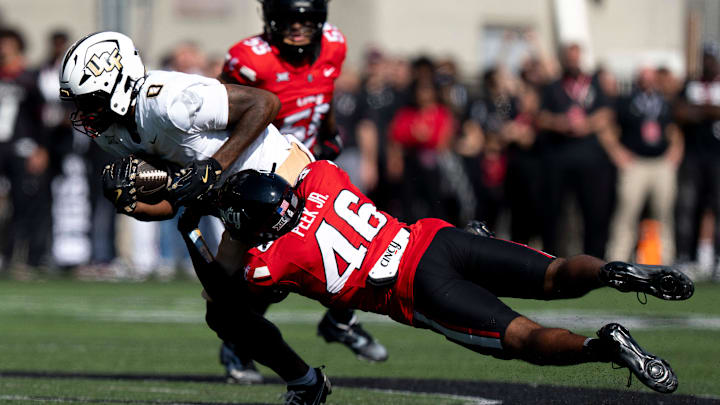 Cincinnati Bearcats defensive back Antwan Peek Jr. (46) tackles UCF Knights tight end Dylan Wade (0) in the first quarter of the NCAA football game between the Cincinnati Bearcats and UCF Knights at Nippert Stadium in Cincinnati on Oct. 11, 2025.