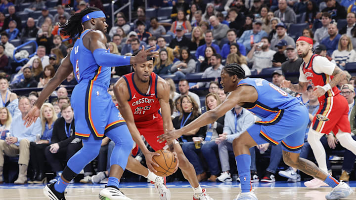 Feb 10, 2025; Oklahoma City, Oklahoma, USA; New Orleans Pelicans guard Trey Murphy III (25) drives between Oklahoma City Thunder guard Luguentz Dort (5) and forward Jalen Williams (8) during the second half at Paycom Center. Mandatory Credit: Alonzo Adams-Imagn Images
