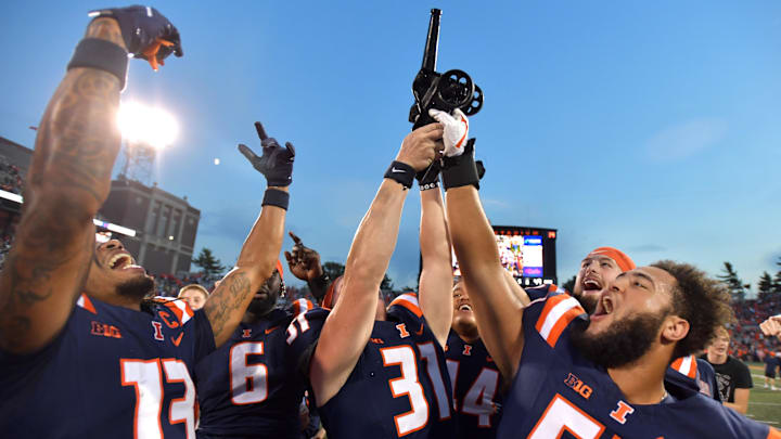 Oct 12, 2024; Champaign, Illinois, USA;  Fighting Illinois players celebrate with the Purdue Cannon in a 50-49 win against the Purdue Boilermakers at Memorial Stadium. Mandatory Credit: Ron Johnson-Imagn Images