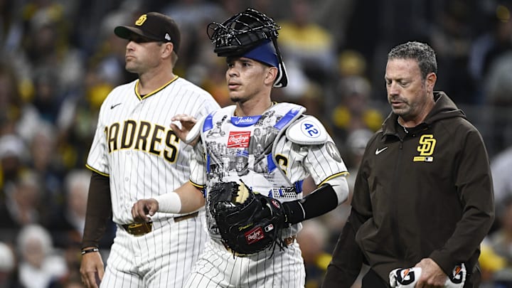 Apr 15, 2026; San Diego, California, USA; San Diego Padres catcher Freddy Fermin, center, leaves the game next to manager Craig Stammen, left, and a trainer during the third inning against the Seattle Mariners at Petco Park. All MLB players are wearing number 42 today to honor Jackie Robinson. Mandatory Credit: Denis Poroy-Imagn Images