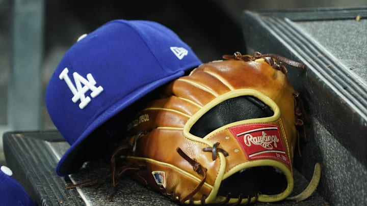 Apr 28, 2024; Toronto, Ontario, CAN; A hat and glove of an Los Angeles Dodgers player durng a game against the Toronto Blue Jays at Rogers Centre. Mandatory Credit: John E. Sokolowski-Imagn Images