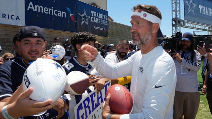 Dallas Cowboys coach Brian Schottenheimer signs autographs at training camp at the River Ridge Fields.