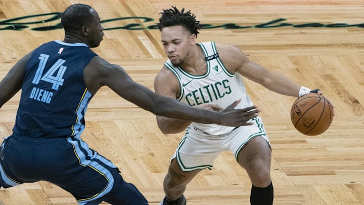Dec 30, 2020; Boston, Massachusetts, USA; Boston Celtics point guard Carsen Edwards (right) dribbles the ball against Memphis Grizzlies center Gorgui Dieng (14) during the fourth quarter at TD Garden. Mandatory Credit: Gregory Fisher-Imagn Images
