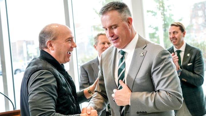 Greg Williams, left, shakes hands with Michigan State's new football coach Pat Fitzgerald during the coach's introductory press conference on Tuesday, Dec. 2, 2025, at the Tom Izzo Football Building in East Lansing.