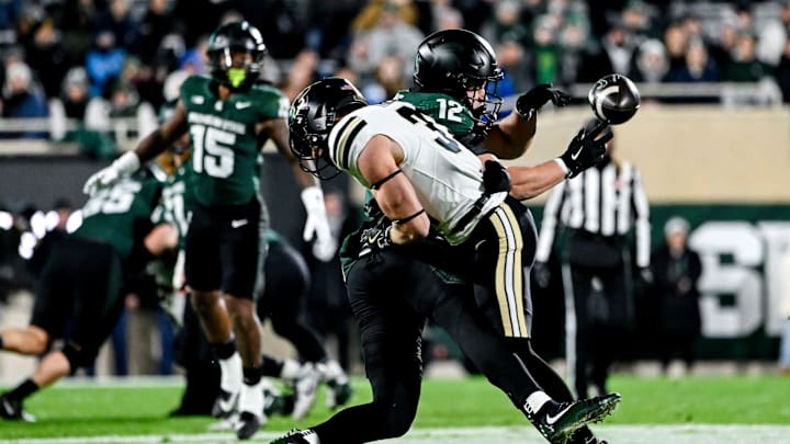 Michigan State's Jack Velling (12) is injured on a hit by Purdue's Dillon Thieneman during the first quarter on Friday, Nov. 22, 2024, at Spartan Stadium in East Lansing.
