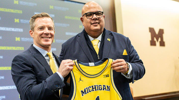 U-M athletic director Warde Manuel presents a jersey to new men's basketball head coach Dusty May during an introductory press conference for Dusty May at Junge Family Champions Center in Ann Arbor on Tuesday, March 26, 2024.