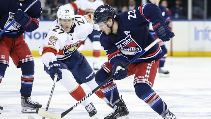 Mar 23, 2024; New York, New York, USA; Florida Panthers center Eetu Luostarinen (27) and New York Rangers defenseman Adam Fox (23) battle for control of the puck in the third period at Madison Square Garden. Mandatory Credit: Wendell Cruz-USA TODAY Sports