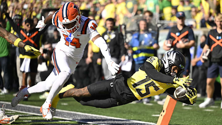 Oct 26, 2024; Eugene, Oregon, USA; Oregon Ducks wide receiver Tez Johnson (15) scores a touchdown during the first half against Illinois Fighting Illini defensive back Xavier Scott (14) at Autzen Stadium.