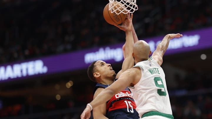 Nov 22, 2024; Washington, District of Columbia, USA; Washington Wizards guard Malcolm Brogdon (15) shoots the ball as Boston Celtics guard Derrick White (9) and Celtics forward Sam Hauser (30) defend in the second half at Capital One Arena. Mandatory Credit: Geoff Burke-Imagn Images Nov 22, 2024; Washington, District of Columbia, USA; Washington Wizards guard Malcolm Brogdon (15) shoots the ball as Boston Celtics guard Derrick White (9) and Celtics forward Sam Hauser (30) defend in the second half at Capital One Arena. Mandatory Credit: Geoff Burke-Imagn Images