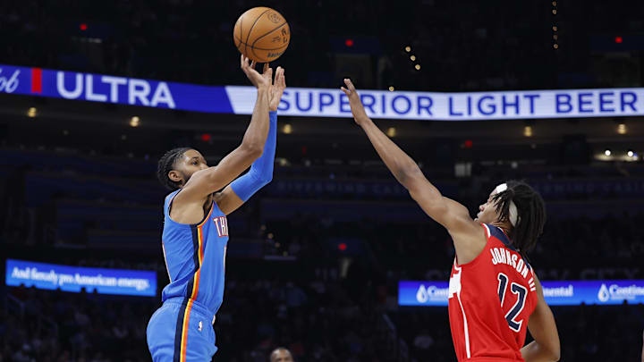 Oct 30, 2025; Oklahoma City, Oklahoma, USA; Oklahoma City Thunder guard Isaiah Joe (11) shoots a three point basket over Washington Wizards guard Tre Johnson (12) during the second half at Paycom Center. Mandatory Credit: Alonzo Adams-Imagn Images