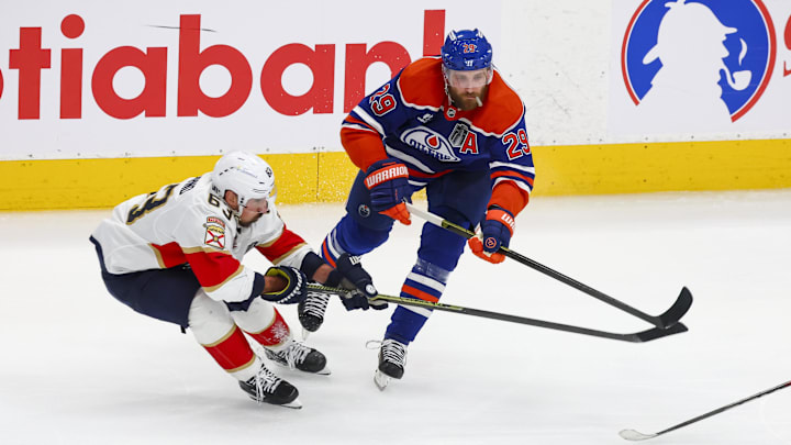 Jun 14, 2025; Edmonton, Alberta, CAN; Florida Panthers forward Brad Marchand (63) reaches for the puck against Edmonton Oilers center Leon Draisaitl (29) during the third period in game five of the 2025 Stanley Cup Final at Rogers Place. Mandatory Credit: Sergei Belski-Imagn Images