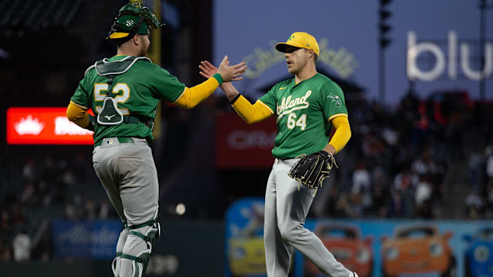 Mar 26, 2024; San Francisco, California, USA; Oakland Athletics battery Kyle McCann (52) and Vinny Nittoli (64) celebrate their 3-1 victory over the San Francisco Giants at Oracle Park. Mandatory Credit: D. Ross Cameron-Imagn Images