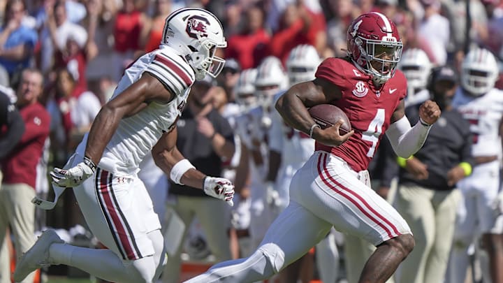 Oct 12, 2024; Tuscaloosa, Alabama, USA;  Alabama Crimson Tide quarterback Jalen Milroe (4) runs away from a South Carolina defender at Bryant-Denny Stadium. Mandatory Credit: Gary Cosby Jr.-Imagn Images