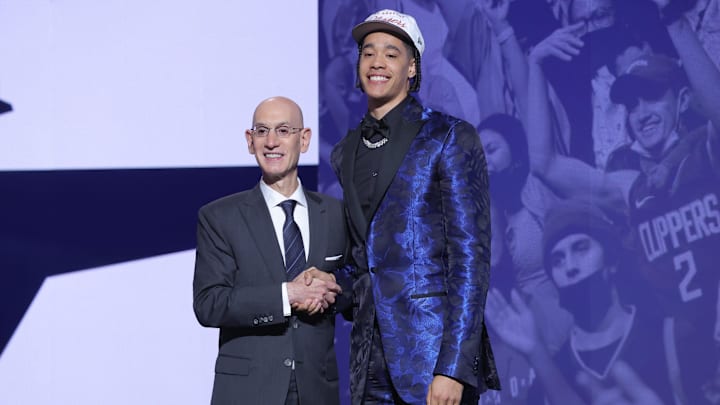 Penn State's Yanic Konan Niederhauser stands with NBA commissioner Adam Silver after being selected as the 30th pick by the Los Angeles Clippers in the first round of the 2025 NBA Draft. 