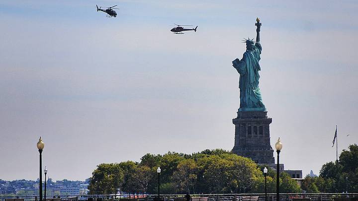 Two helicopters are seen hovering around the Statue of Liberty at Liberty State Park in Jersey City.