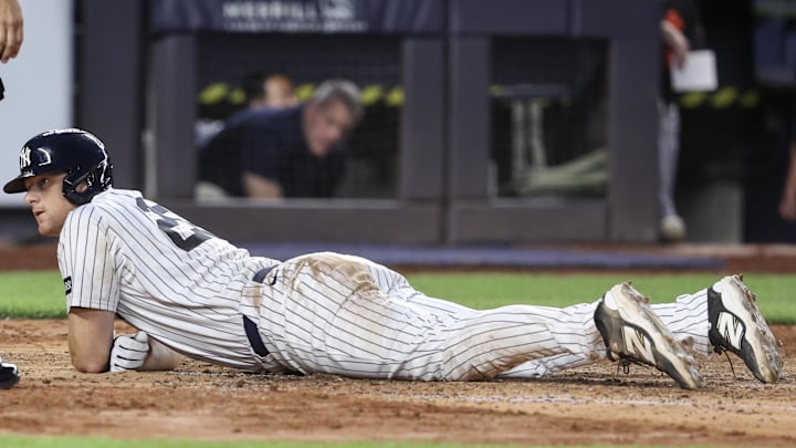 Jun 20, 2025; Bronx, New York, USA;  New York Yankees second baseman DJ LeMahieu (26) lays on the ground after getting tagged out at home plate in the fourth inning against the Baltimore Orioles at Yankee Stadium. Mandatory Credit: Wendell Cruz-Imagn Images