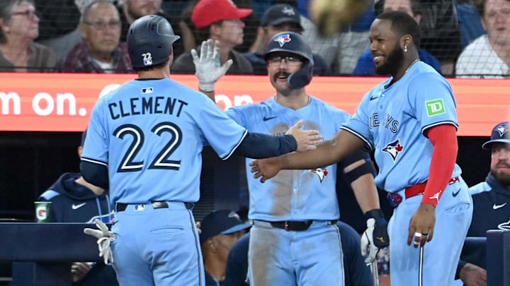 Jul 23, 2025; Toronto, Ontario, CAN;  Toronto Blue Jays third baseman Ernie Clement (22) is greeted by left fielder Davis Schneider (36) and Vladimir Guerrero Jr. (27, right) after scoring a run against the New York Yankees in the sixth inning at Rogers Centre. 