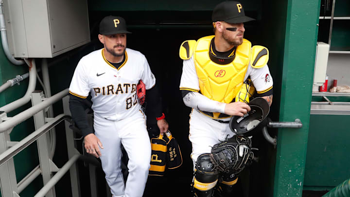 Pittsburgh Pirates catching assistant Jordan Comadena (82) and catcher Yasmani Grandal (right) enter the dugout before the game against the Chicago Cubs at PNC Park. 