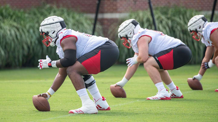 Louisville linemen practice snapping the football in spring ball.