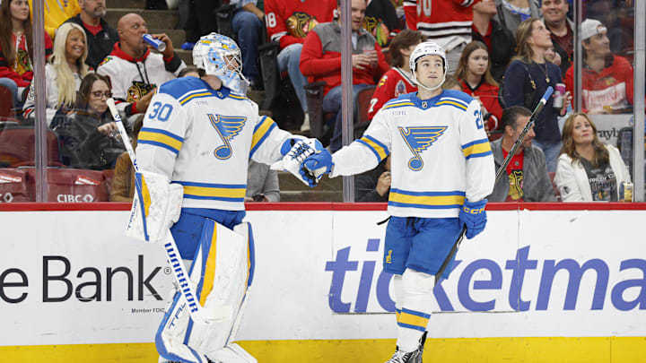 Apr 11, 2026; Chicago, Illinois, USA; St. Louis Blues right wing Jimmy Snuggerud (21) celebrates with goaltender Joel Hofer (30) after scoring against the Chicago Blackhawks during the first period at United Center. Mandatory Credit: Kamil Krzaczynski-Imagn Images