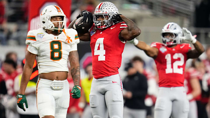 Ohio State Buckeyes wide receiver Jeremiah Smith (4) celebrates a first down beside Miami Hurricanes defensive back Jakobe Thomas (8) during the Cotton Bowl at AT&T Stadium in Arlington, Texas for the College Football Playoff quarterfinal game on Dec. 31, 2025. Ohio State lost 24-14.