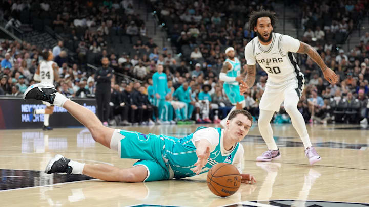 Charlotte Hornets center Ryan Kalkbrenner (11) reaches for a loose ball in front of San Antonio Spurs forward Charlotte Hornets center Ryan Kalkbrenner (11) reaches for a loose ball in front of San Antonio Spurs forward