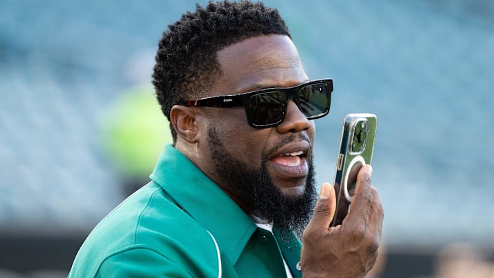 Actor Kevin Hart talks on the phone during warm ups between the Philadelphia Eagles and the Minnesota Vikings 