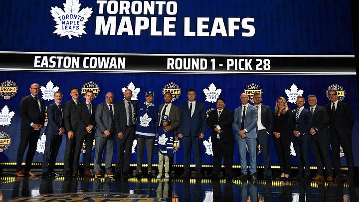 Jun 28, 2023; Nashville, Tennessee, USA; Toronto Maple Leafs draft pick Easton Cowan stands with Leafs staff after being selected with the twenty eighth pick in round one of the 2023 NHL Draft at Bridgestone Arena. Mandatory Credit: Christopher Hanewinckel-Imagn Images