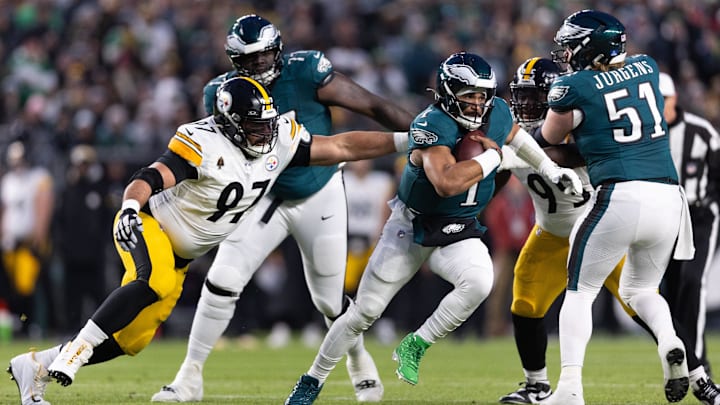 Dec 15, 2024; Philadelphia, Pennsylvania, USA; Philadelphia Eagles quarterback Jalen Hurts (1) runs with the ball past Pittsburgh Steelers offensive tackle Calvin Anderson (67) during the first quarter at Lincoln Financial Field. Mandatory Credit: Bill Streicher-Imagn Images