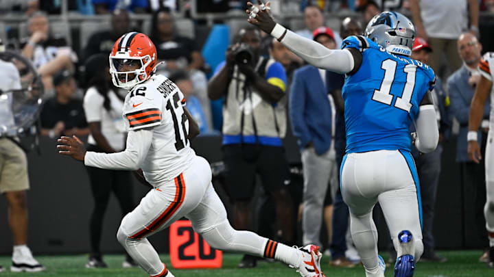 Aug 8, 2025; Charlotte, North Carolina, USA; Cleveland Browns quarterback Shedeur Sanders (12) scrambles as Carolina Panthers linebacker Nic Scourton (11) pressures in the second quarter at Bank of America Stadium. Mandatory Credit: Bob Donnan-Imagn Images