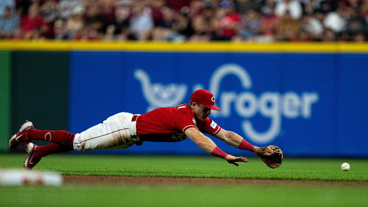 Cincinnati Reds second baseman Matt McLain (9) dives for a ball hit by Cleveland Guardians third baseman Jose Ramirez (11) in the eighth inning of the MLB baseball game between the Cincinnati Reds and the Cleveland Guardians at Great American Ball Park in Cincinnati on Wednesday, Aug. 16, 2023.