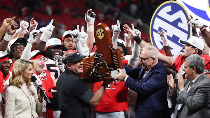 Dec 6, 2025; Atlanta, GA, USA; Georgia Bulldogs head coach Kirby Smart lifts the SEC Championship trophy after the game against the Alabama Crimson Tide during the 2025 SEC Championship game at Mercedes-Benz Stadium. Mandatory Credit: Brett Davis-Imagn Images