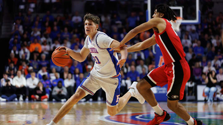 Jan 25, 2025; Gainesville, Florida, USA; Florida Gators forward Alex Condon (21) drives to the basket while Georgia Bulldogs guard Jordyn Kee (4) defends during the second half at Exactech Arena at the Stephen C. O'Connell Center. Mandatory Credit: Matt Pendleton-Imagn Images
