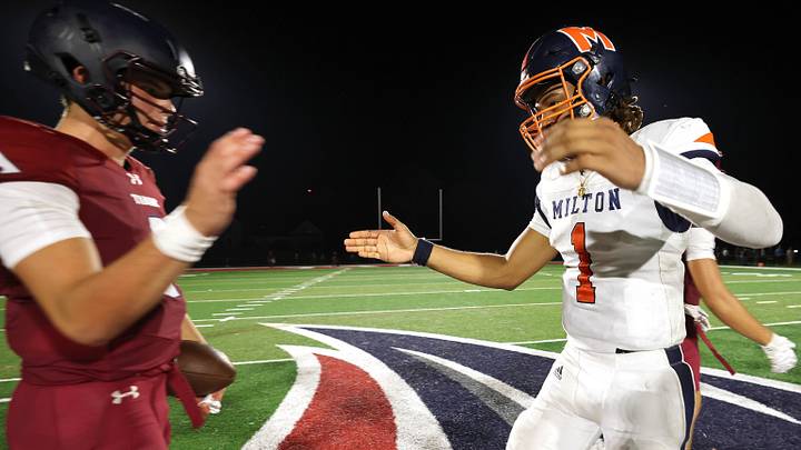 Tabor Academy quarterback Peter Bourque, left, and Milton Academy quarterback Qur'an McNeill at the conclusion of their game on Friday, Sept. 26, 2025.