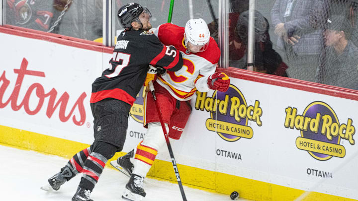 Oct 30, 2025; Ottawa, Ontario, CAN; Ottawa Senators left wing David Perron (57) takes Calgary Flames defenseman Joey Hanley (44) off the puck in the third period at the Canadian Tire Centre. Mandatory Credit: Marc DesRosiers-IMAGN Images