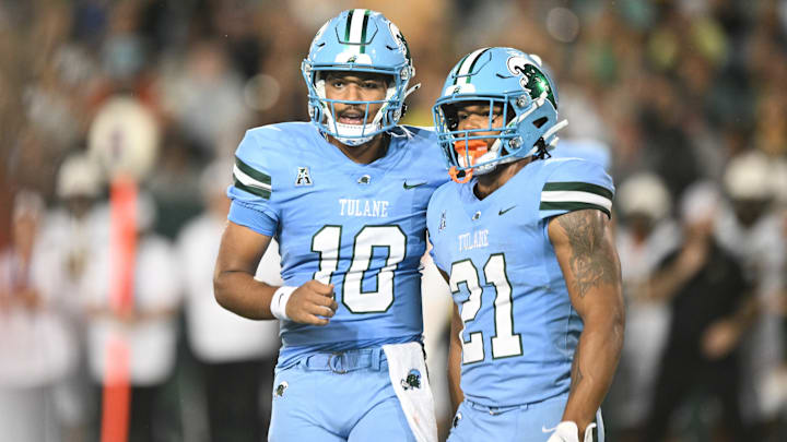 Tulane Green Wave players Darian Mensah (10) and Makhi Hughes (21) stand next to each other. Tulane Green Wave players Darian Mensah (10) and Makhi Hughes (21) stand next to each other.