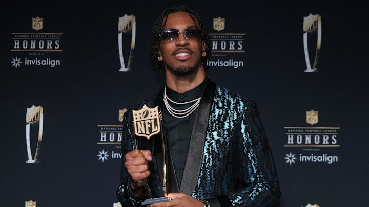 Washington Commanders quarterback Jayden Daniels poses with the Offensive Rookie of the Year award.