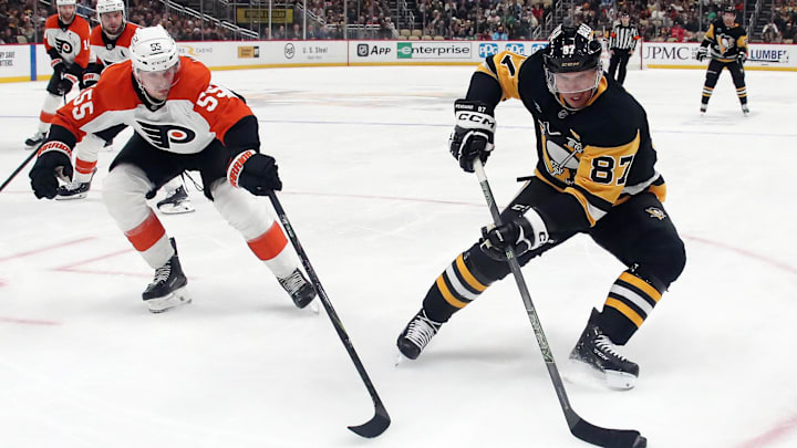 Dec 23, 2024; Pittsburgh, Pennsylvania, USA;  Pittsburgh Penguins center Sidney Crosby (87) handles the puck against Philadelphia Flyers defenseman Rasmus Ristolainen (55) during the third period at PPG Paints Arena. Mandatory Credit: Charles LeClaire-Imagn Images
