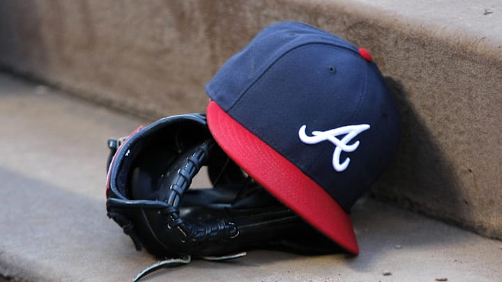 Aug 25, 2015; Atlanta, GA, USA; Detailed view of Atlanta Braves hat and glove in the dugout before a game against the Colorado Rockies at Turner Field. Mandatory Credit: Brett Davis-Imagn Images
