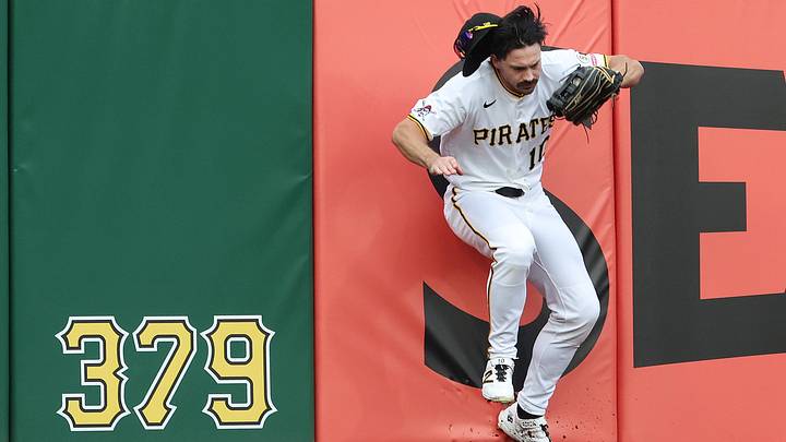 Jun 11, 2026; Pittsburgh, Pennsylvania, USA;  Pittsburgh Pirates left fielder Bryan Reynolds (10) crashes into the wall after robbing Los Angeles Dodgers shortstop Mookie Betts (not pictured) of a home run during the third inning at PNC Park. Mandatory Credit: Charles LeClaire-Imagn Images