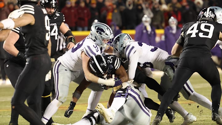 Nov 30, 2024; Ames, Iowa, USA; Iowa State Cyclones running back Abu Sama III (24) is tackled by Kansas State Wildcats defensive end Travis Bates (39) during the third quarter at Jack Trice Stadium. Mandatory Credit: Reese Strickland-Imagn Images