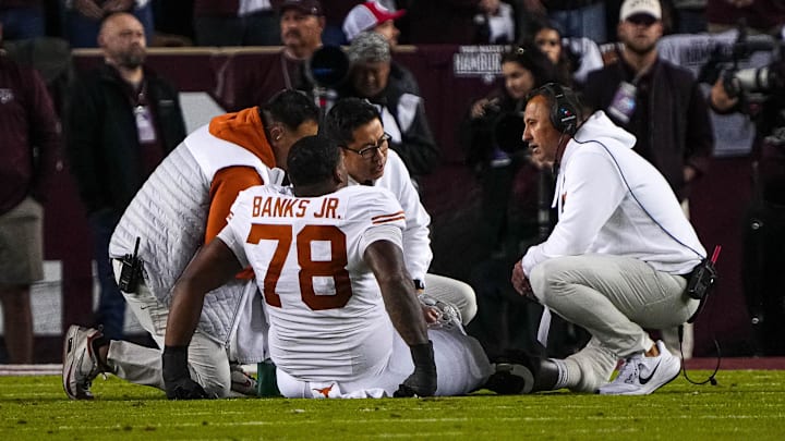 Nov 30, 2024; College Station, Texas, USA; Texas Longhorns head coach Steve Sarkisian checks on injured offensive lineman Kelvin Banks Jr. (78) during the Lone Star Showdown against the Texas A&M Aggies at Kyle Field. Mandatory Credit: Sara Diggins/USA TODAY Network via Imagn Images Nov 30, 2024; College Station, Texas, USA; Texas Longhorns head coach Steve Sarkisian checks on injured offensive lineman Kelvin Banks Jr. (78) during the Lone Star Showdown against the Texas A&M Aggies at Kyle Field. Mandatory Credit: Sara Diggins/USA TODAY Network via Imagn Images