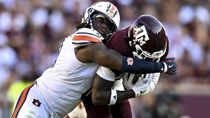 Sep 27, 2025; College Station, Texas, USA; Auburn Tigers linebacker Robert Woodyard Jr. (0) wraps up Texas A&M Aggies running back Le'Veon Moss (8) during the third quarter at Kyle Field. Mandatory Credit: Maria Lysaker-Imagn Images 