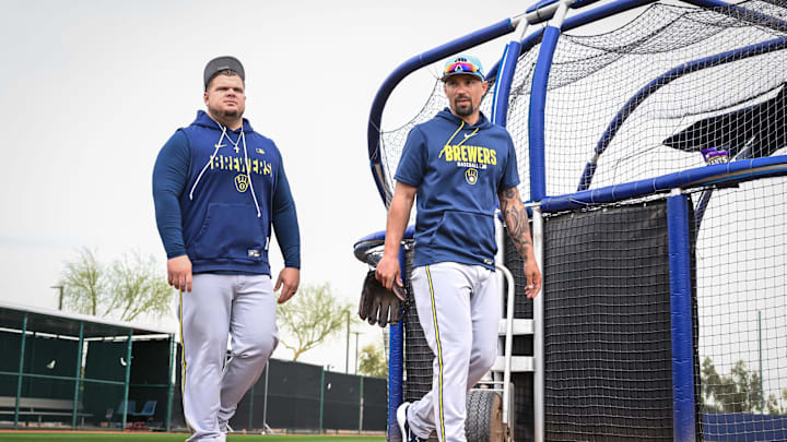 Milwaukee Brewers hitting coach Daniel Vogelbach, left, and consultant Jace Peterson walk behind the batting cage during spring training workouts Monday, February 16, 2026, at American Family Fields of Phoenix in Phoenix, Arizona.