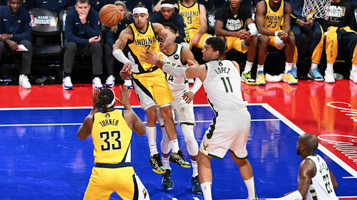 Dec 7, 2023; Las Vegas, Nevada, USA;  Indiana Pacers guard Andrew Nembhard (2) makes a pass to center Myles Turner (33) as Milwaukee Bucks center Brook Lopez (11) defends during the fourth quarter at T-Mobile Arena. Mandatory Credit: Candice Ward-Imagn Images